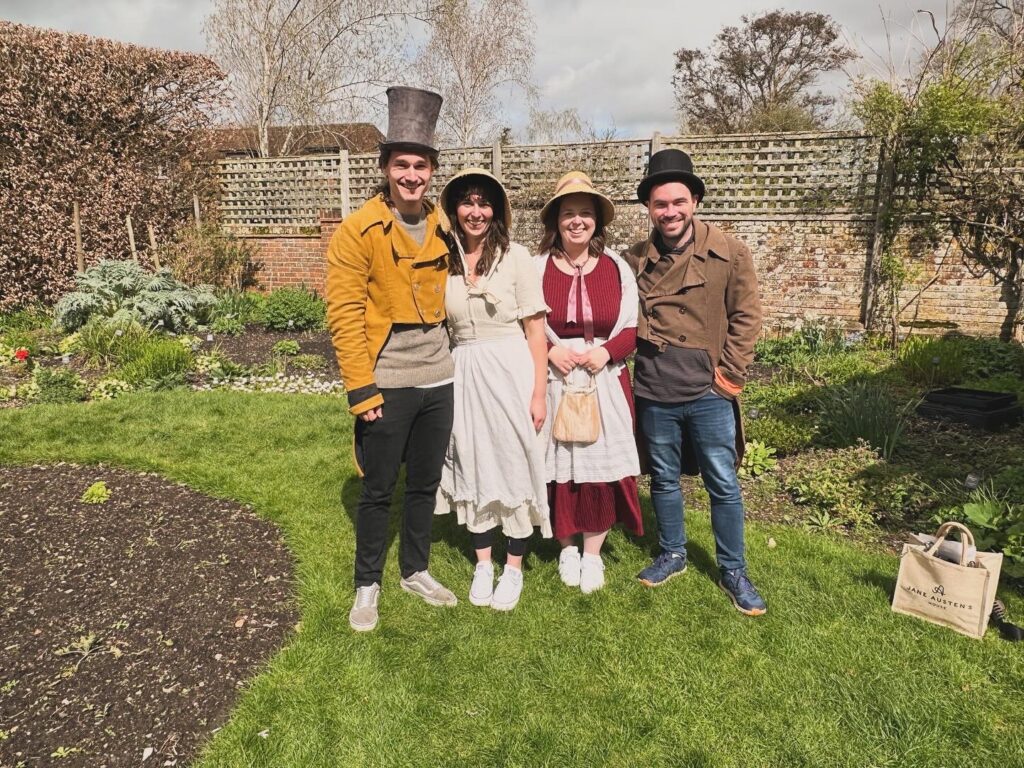 4 people dressed up standing on the grass