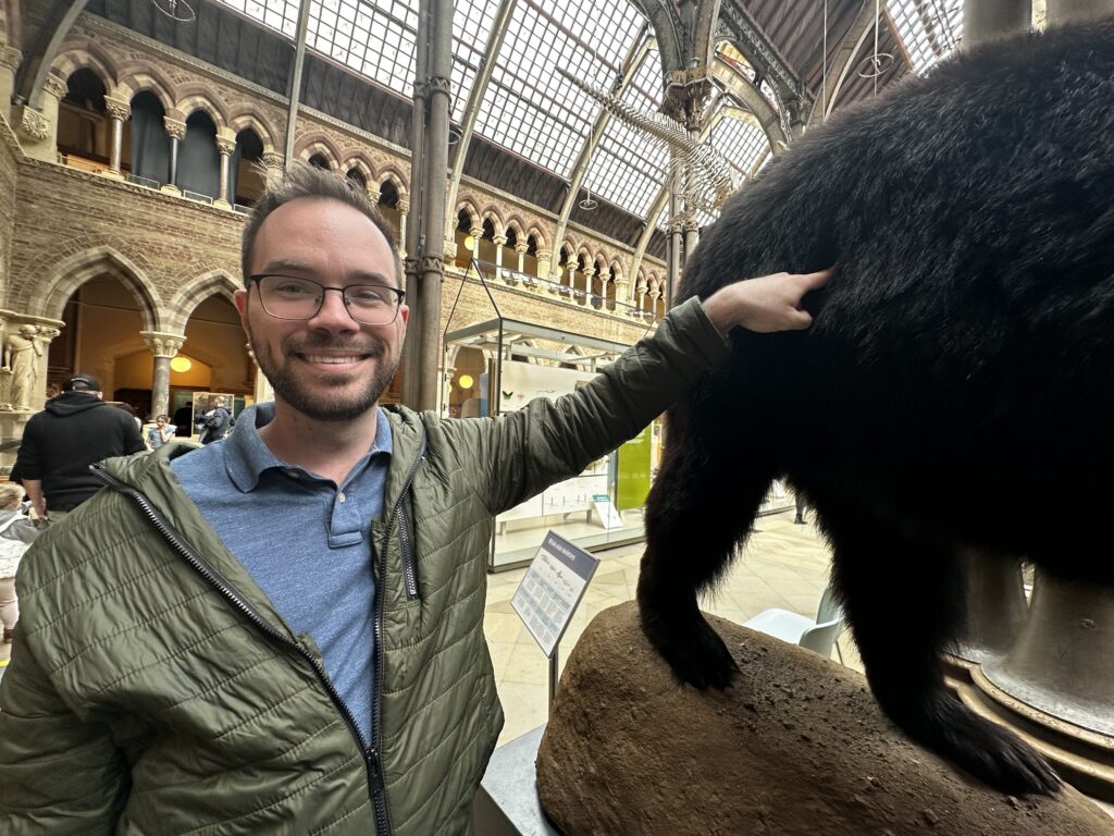  A man pointing at the bum of a stuffed bear in the Oxford Natural History Museum. 